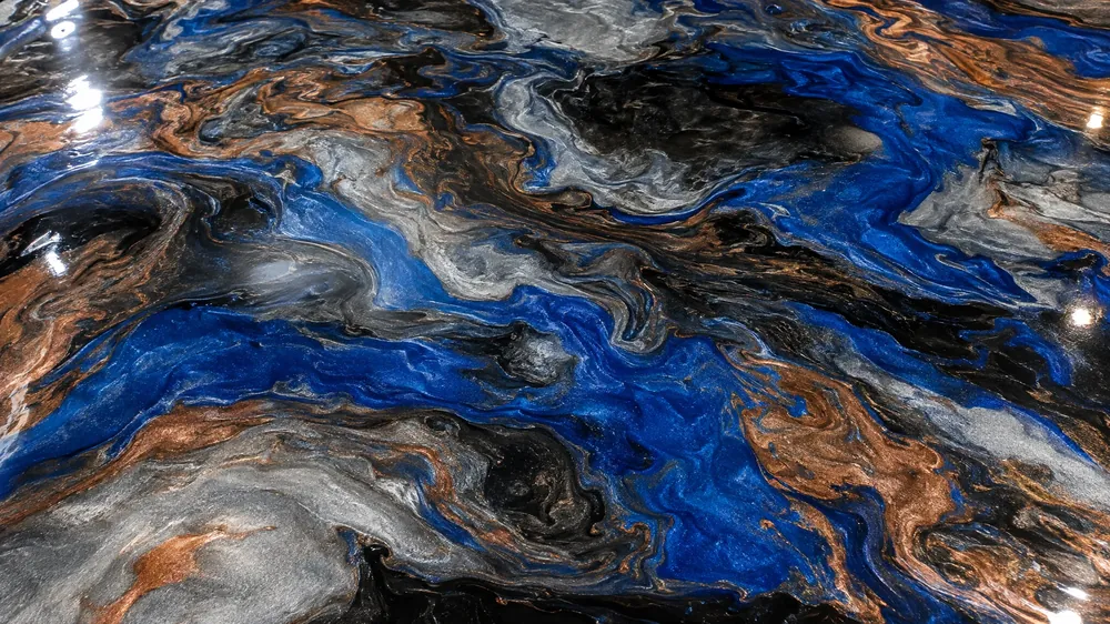 Top-down close-up of a blue, silver, black and copper swirling metallic epoxy floor